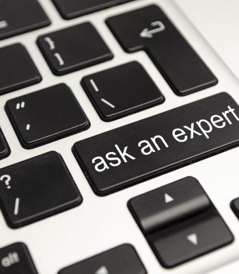 Close up button with the words ask an Expert, on a black keyboard. Creative background, copy space.